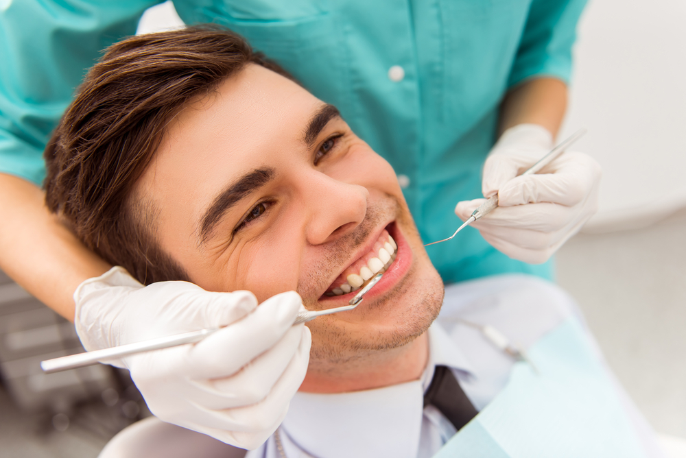 Young attractive man on a review of the doctor dentist. Close-up