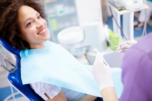 Young adult smiling during wisdom teeth removal process at Dens Dental Studio in Chicago, IL.