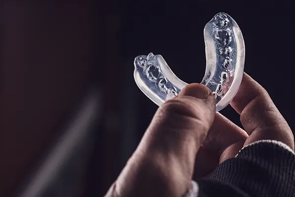 Dentist holding up a sports mouthguard at Dens Dental Studio in Chicago, IL.
