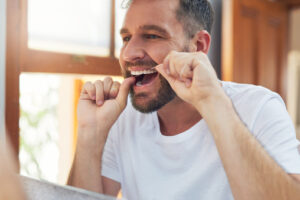Man flossing his teeth at Dens Dental Studio in Chicago, IL