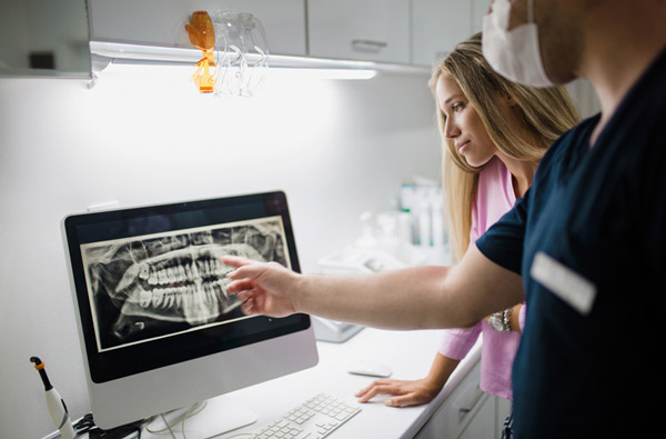 Dentist and assistant discussing patients x-rays at Dens Dental Studio in Uptown Chicago, IL.