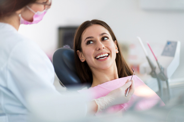 Young woman smiling after receiving toothache treatment at Dens Dental Studio in Uptown Chicago, IL.