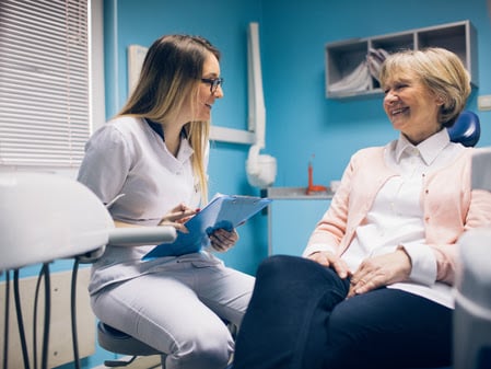 Dentist and older female patient talking about dental implant process at Dens Dental Studio in Uptown Chicago, IL.