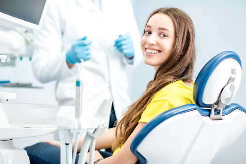 Young girl smiling during her dental exam at Dens Dental Studio in Uptown Chicago, IL.