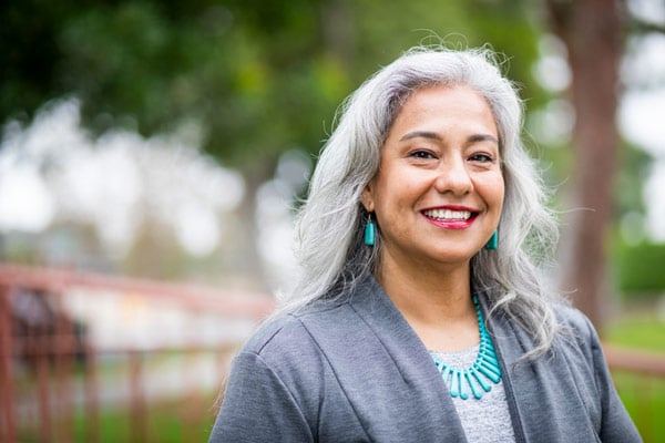 Older woman smiling after receiving dental implants at Dens Dental Studio in Uptown Chicago, IL.